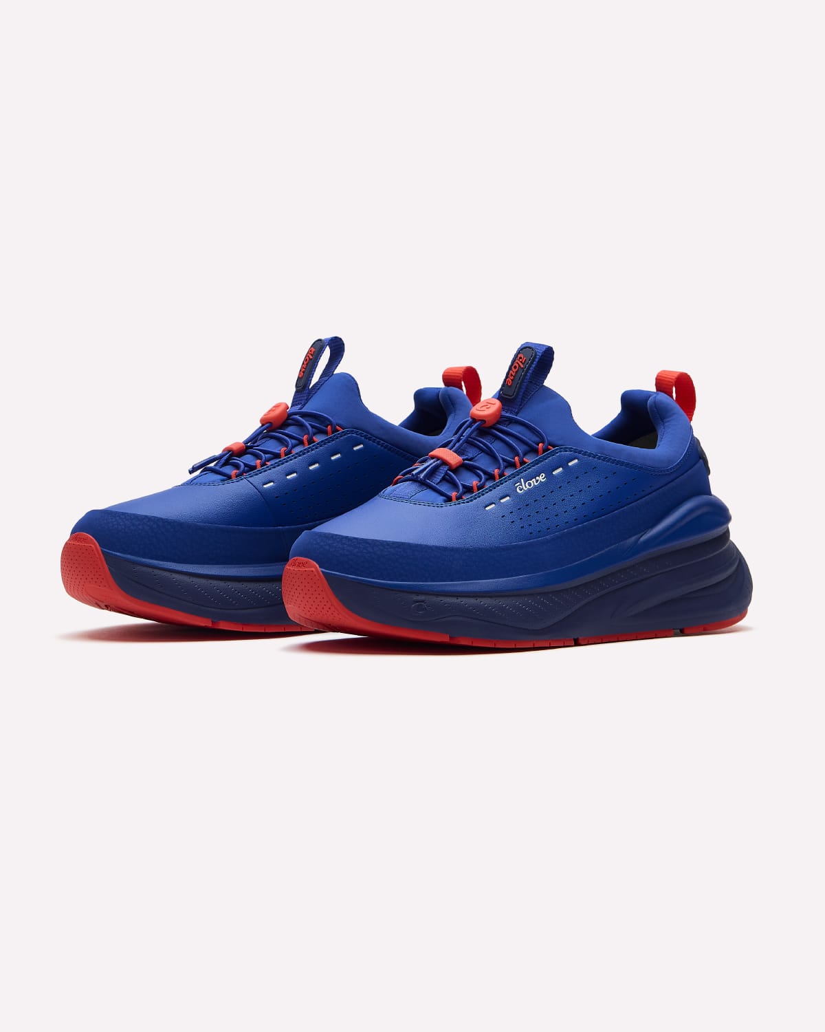 A pair of blue sneakers with red accents, including the bottoms, laces, and pull tabs, displayed on a clean off-white background.