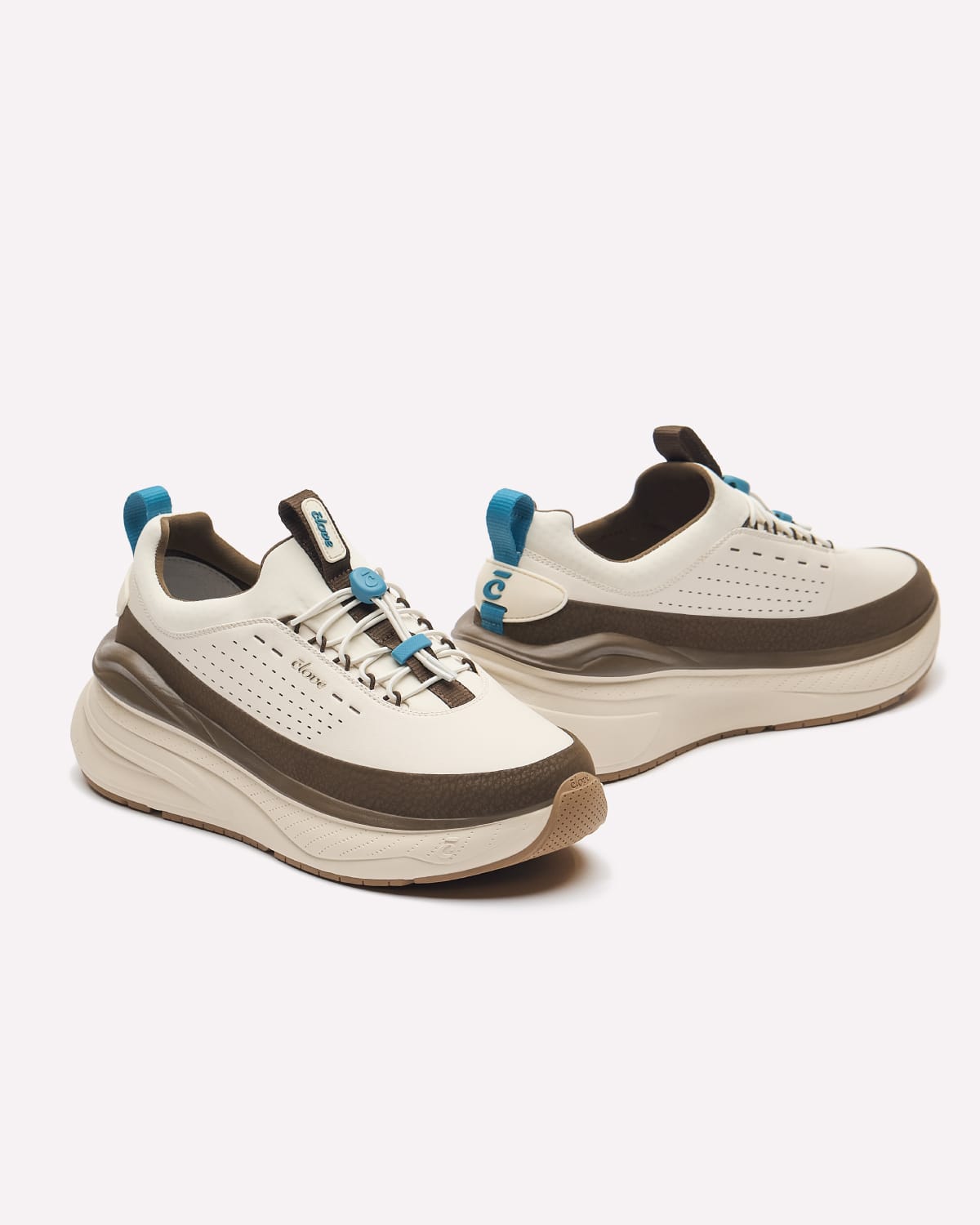 A pair of chunky platform sneakers in off-white, dark brown, and light blue, shown from a three-quarters angle on a light gray background.