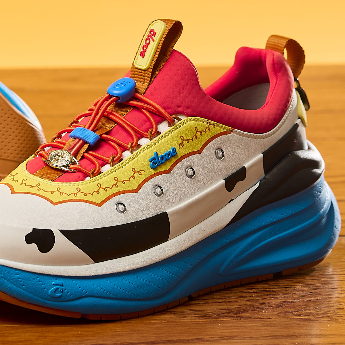 Colorful sneaker with cartoonish design on a wooden surface