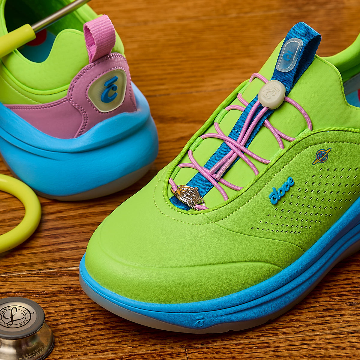Colorful shoes with pink laces on a wooden surface