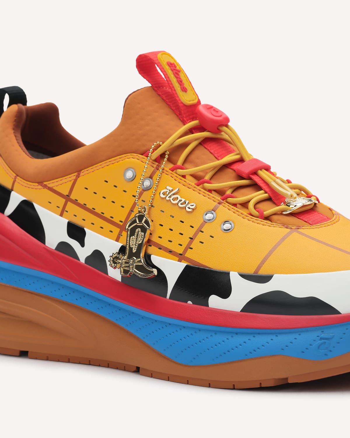 Colorful sneaker with cow print and decorative elements on a white background