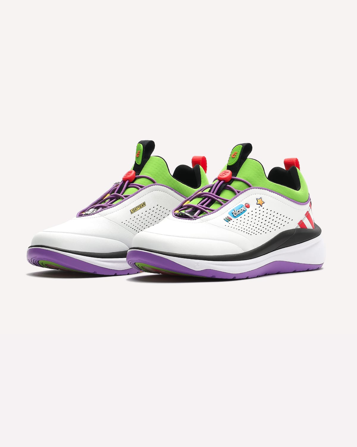 Pair of white athletic shoes with green and purple accents on a white background