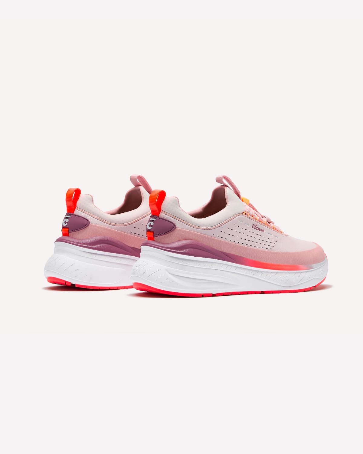 Pair of pink and white sneakers with red accents on a light gray background
