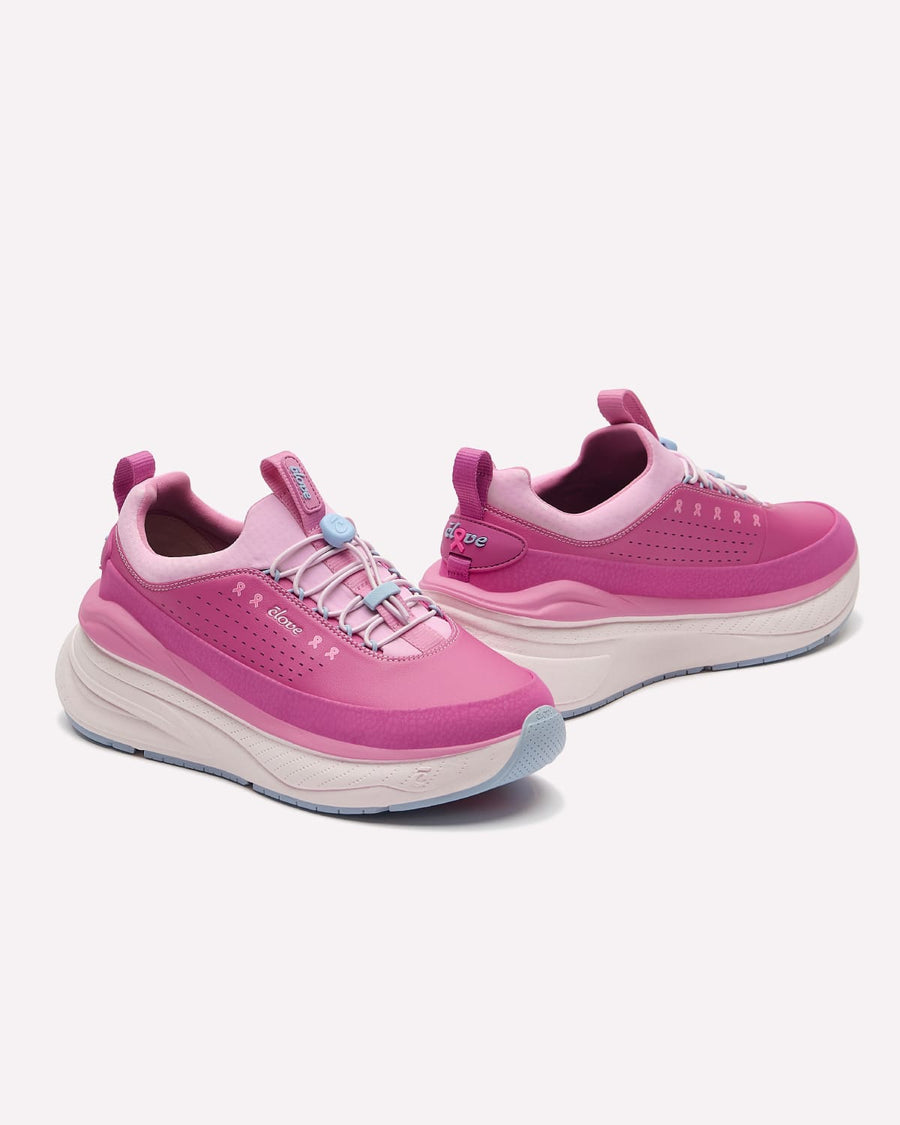 A pair of pink and magenta athletic sneakers with chunky white and light blue bottom, displayed on a clean off-white background.