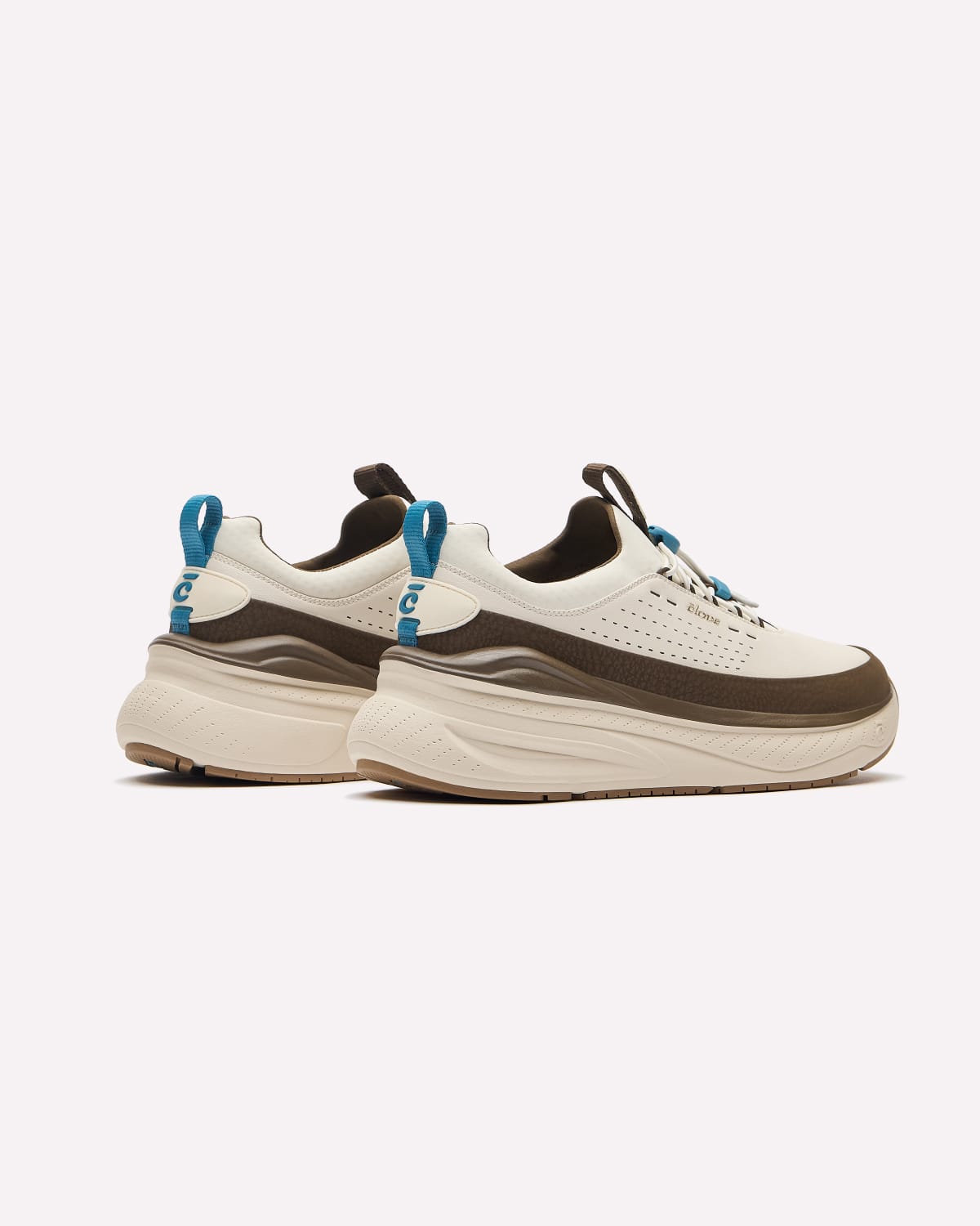 A pair of chunky platform sneakers in off-white and brown, featuring bright blue pull tabs on the heel and tongue, set against a plain light gray background.